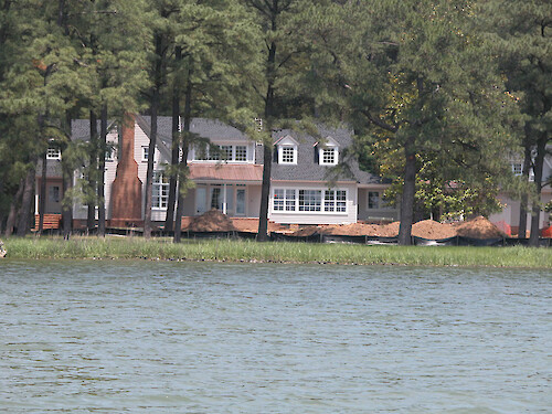 This home under construction is situated in a pine forest. A silt fence has been installed in an attempt to prevent sedimentation into the wetlands. Unfortunately, even a building setback does little to prevent septic systems from failing due to frequent flooding and nutrient-laden runoff into the river.
May 2005, Tred Avon River, Easton, MD