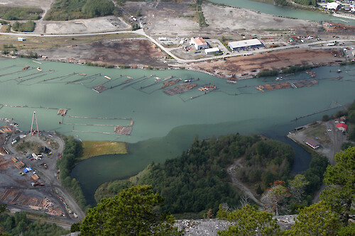 Log booms on the Howe Sound, just near Squamish, British Columbia. Also the lumber sorting yard in the bottom left of the photo.
