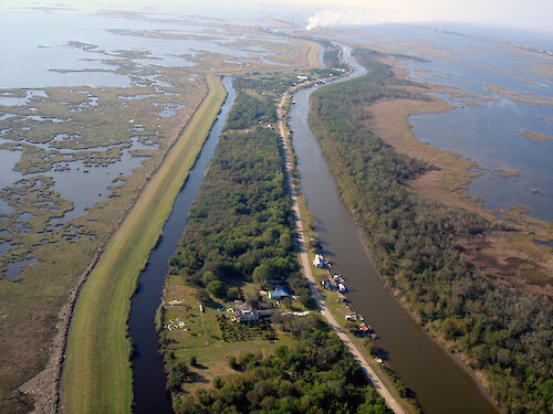 A flood protection barrier helps a small bayou community in coastal louisiana to remain amongst rapidly eroding wetlands