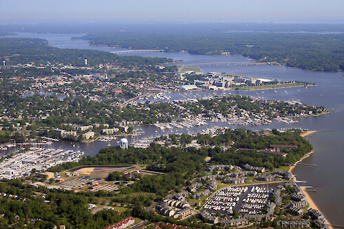 View across Annapolis. From front to back: Back Creek, Spa Creek, Severn River. Also visible are the US Naval Academy, and the Route 450 and Route 50 bridges. The Anne Arundel wastewater treatment plant is visible front left.