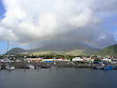 Taken from within the walls of the marina, a rainbow bridges over the hills to the NW of the town of Basseterre.