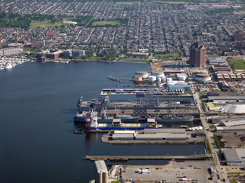 Dock yards and ships in the Patapsco River in Baltimore, Maryland. The city of Baltimore is in the background.