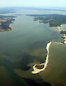 Looking northwest over Sandy Point on Gwynns Island, Virginia. Seagrass (submerged aquatic vegetation) is visible behind the sand shoals. The Piankatank River is in the background