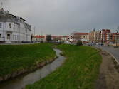 Urban stream with buffer zone in Szombathely, Hungary. Steep banks suggest erosion effects. 