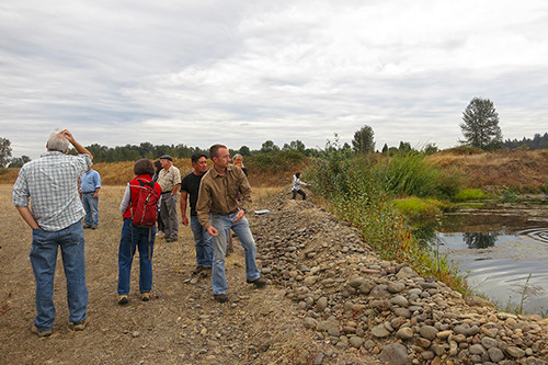 Throwing rocks into one of the old gravel pits on site at the Willamette Confluence Project.