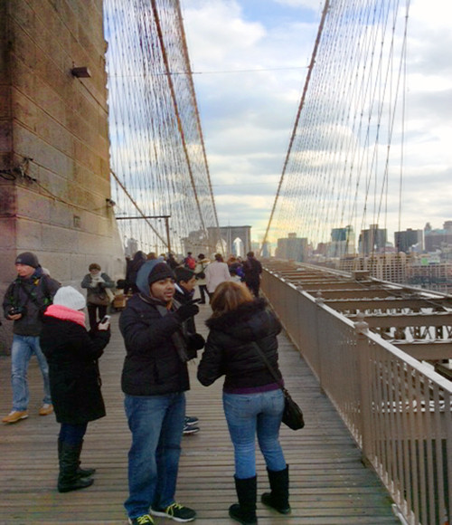 Walking across the Brooklyn Bridge promenade one hundred and thirty one years after it was opened.