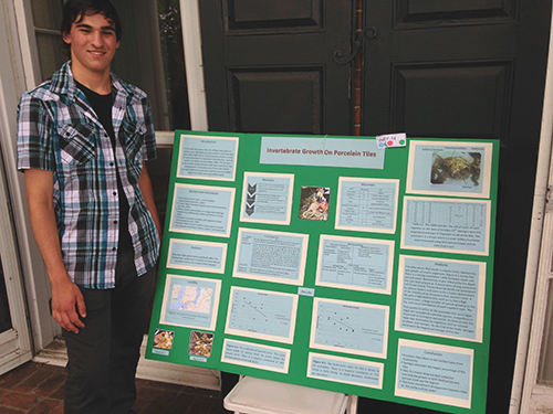 Andrew Summer, pictured with his senior research project on invertebrate growth. Credit: Dylan Taillie
