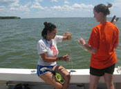 A student and teacher taking water quality samples. 