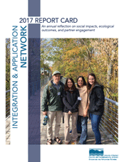 Image shows the cover of the IAN Report Card 2017 with Integration & Application Network written vertically down the left side of the page, a photo of 4 IAN staff on a walking bridge in the woods smiling at the camera, and the words 