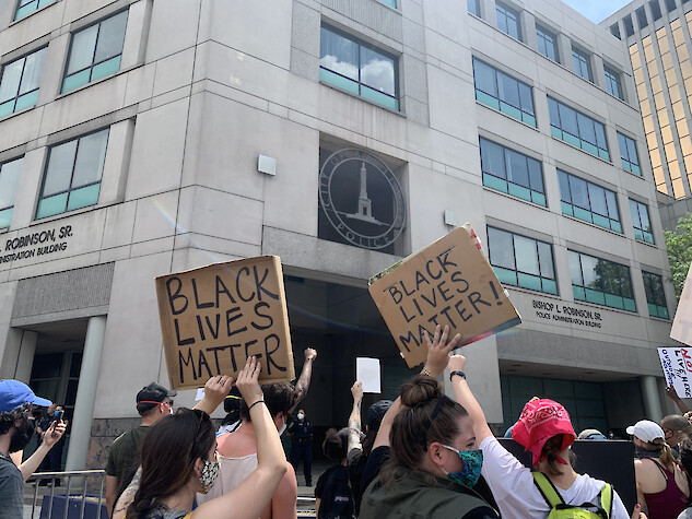 Image of protest signs during a Black Lives Matter protest in front of a police building located in Baltimore, MD.