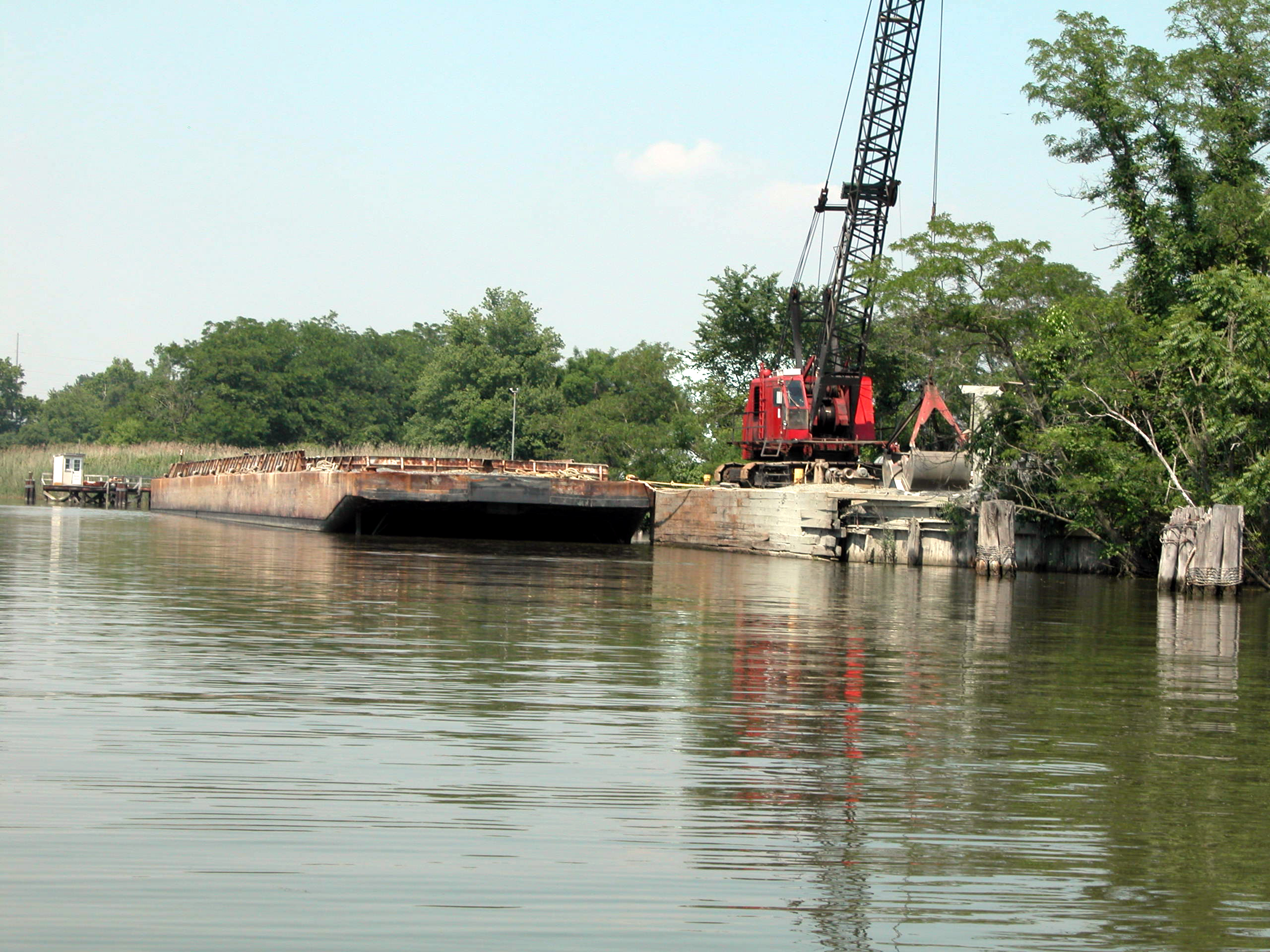 Asphalt production plant's waterfront depot, empty gravel barge and crane Media Library