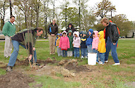 Natural Resources personnel plant trees with local elementary school students.
