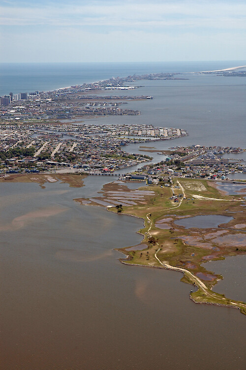Aerial view of the canal joining Little Assawoman Bay (bottom left) with Assawoman Bay (top right). Assateague Island is visible in the background.