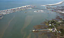 Aerial view of the Ocean City Inlet from Isle of Wight Bay. Also visible are Skimmer Island, the northern end of Assateague Island and Sinepuxent Bay, and the Route 50 bridge.