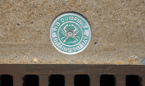 These signs on stormwater drains remind people that water flowing into these grates drains into Chesapeake Bay