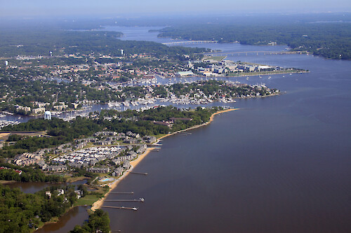 View across Annapolis. From front to back: Back Creek, Spa Creek, Severn River. Also visible are the US Naval Academy, and the Route 450 and Route 50 bridges. The Anne Arundel wastewater treatment plant is visible front left.