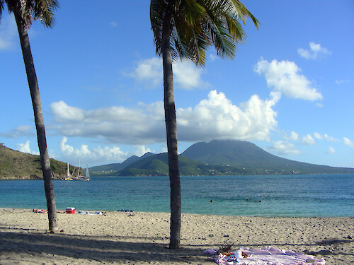 Taken from the south shore of St. Kitts, a view of the volcanic sister island of Nevis is enjoyed.