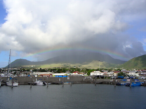 Taken from within the walls of the marina, a rainbow bridges over the hills to the NW of the town of Basseterre.