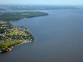 Western shoreline of Chesapeake Bay, showing urban development in foreground and forest in the background.
