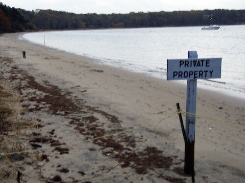 No trespassing sign on the beach at Waquoit Bay. 