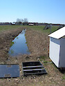 Drainage ditch, control structure, and solar-powered control station in a field in the Choptank Watershed.