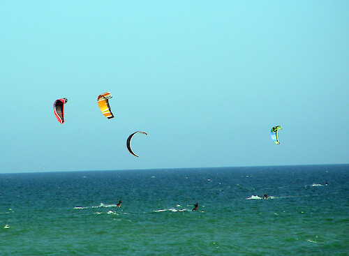 Launching from Praia de Faro, kite surfers ride the wind and the waves of the Atlantic Ocean.