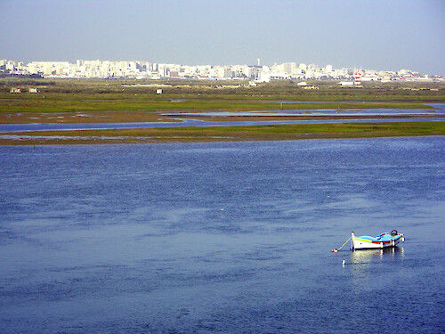 The busy city of Faro, with its airport along the edge, is the backdrop for this view of the wetlands of the Ria Formosa.