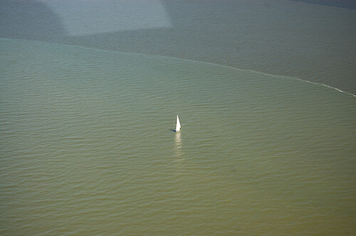 A small sailboat and a sediment plume in the Chesapeake Bay north of the Bay Bridge.