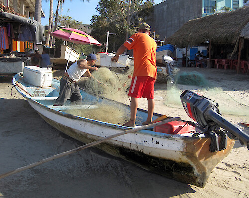In the coastal community of Los Ayala, these fishermen were preparing their nets. This style of open boat with an outboard motor is called a panga, and is hauled up on to the beach when not in use.