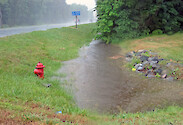 Stormwater ditch full during heavy rains.