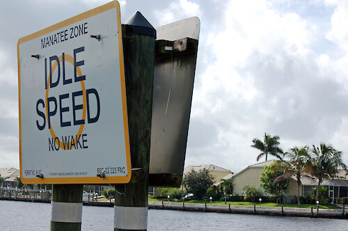 Sign indicating idle speed zone due to manatee presence in Port of the Islands, Florida.