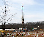 A small well located in Scio, Ohio used for hydraulic fracturing. The tower is the drill used to make the hole which will later be used to shoot liquid down to fracture the rock and extract the petroleum products. Sometime these areas are called Well Pads.