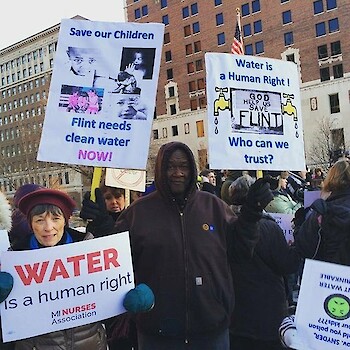 protestors in Flint, Michigan. Signs say "water is a human right" and "save our children"