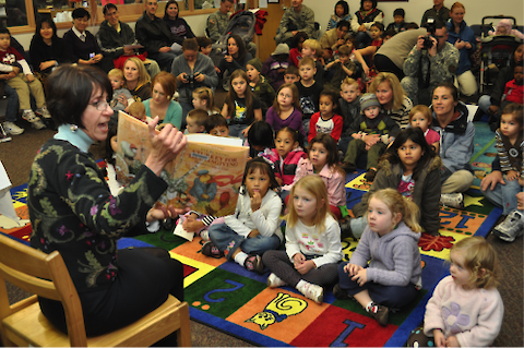Woman reading to children and their parents. Credit: Yongsan Army library (Wikimedia Commons).
