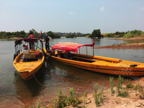 Wooden boats guide tourists on the Mekong River in search of Irrawaddy dolphins. Photo: Brianne Walsh