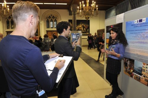 Caricaturer in action while a CommOcean staff films one of the poster presenter
