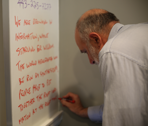 Bill Dennison writes down a quote on the whiteboard. Image credit James Currie