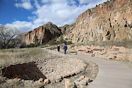 Visitors walking through Pueblo sites at Bandelier National Monument in Los Alamos, NM