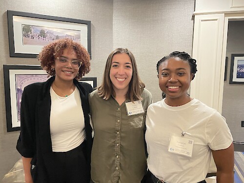 Photo of three individuals standing together and smiling at an event. From left to right: Bailee Porter, Taylor Ouellette, and Kameryn Overton, identified as Global Sustainability Scholars and Fellows, at the Chesapeake Community Research Symposium on June 10, 2024.
